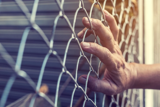 Hand holding on steel net