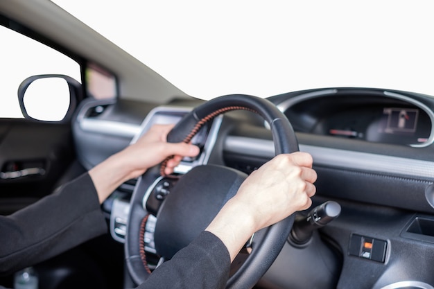 Hand holding steering wheel in modern private car with blank white windshield