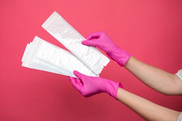 Hand holding sterilization envelopes for manicure in gloves