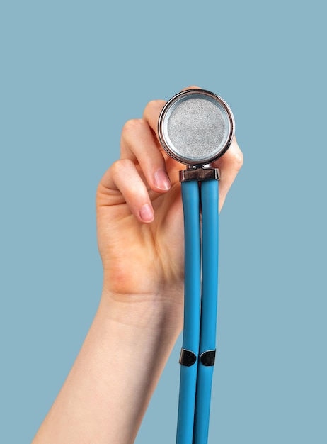 Hand holding stethoscope on blue background to you me