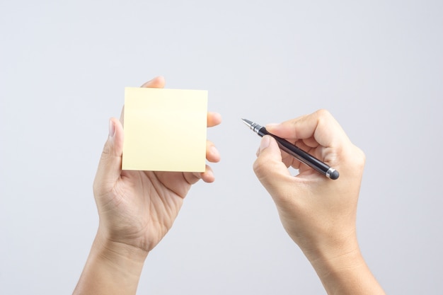 Hand holding sticky post note paper sheet