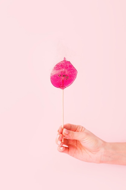Hand holding strawberry against white background