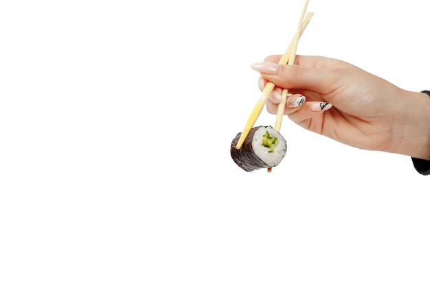 Hand holding sushi rolls with chopsticks