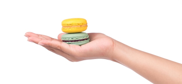 рука держит сладкие и красочные французские миндальные печенья или макароны на белом фоне