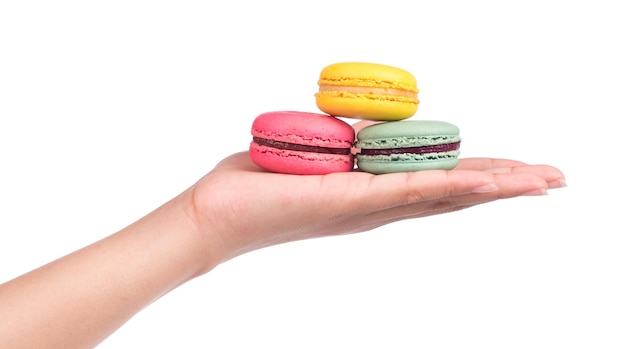 рука держит сладкие и красочные французские миндальные печенья или макароны на белом фоне