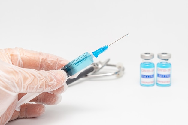 Hand holding syringe containing Covid19 vaccines