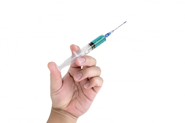 Hand holding syringe on white wall