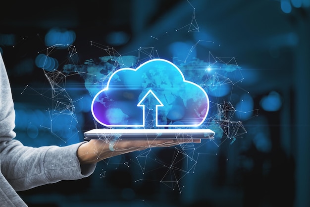 Hand holding tablet with abstract glowing cloud hologram on blurry interior background Cloud computing future and data storage concept Double exposure