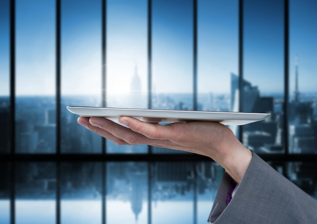 Hand holding tablet with dark windows over city