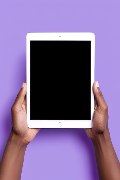 Hand holding tablet with mockup blank screen isolated on purple background