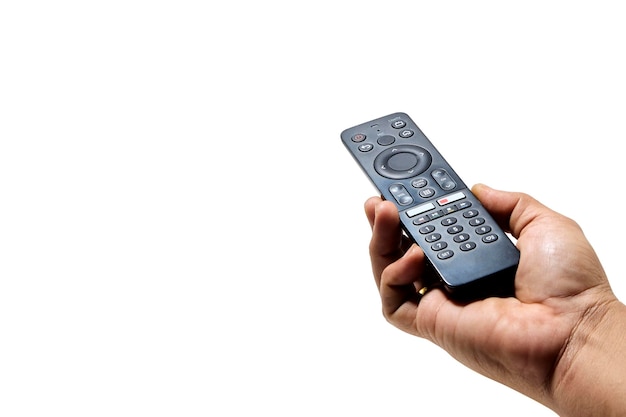 Hand holding television and audio remote control on white background