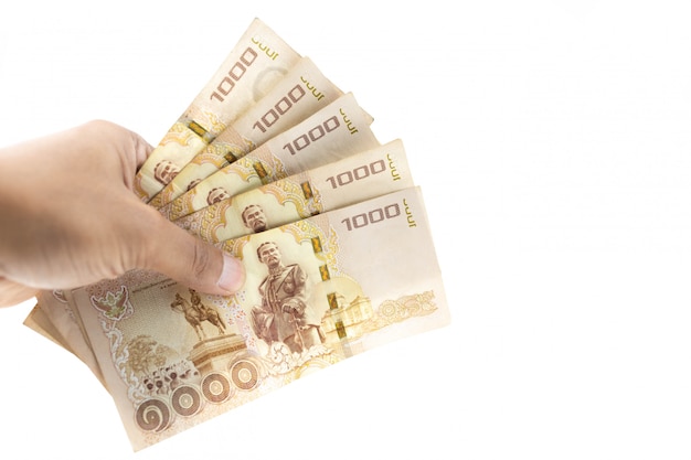 Hand holding Thai banknotes five thousand baht isolated on white background.