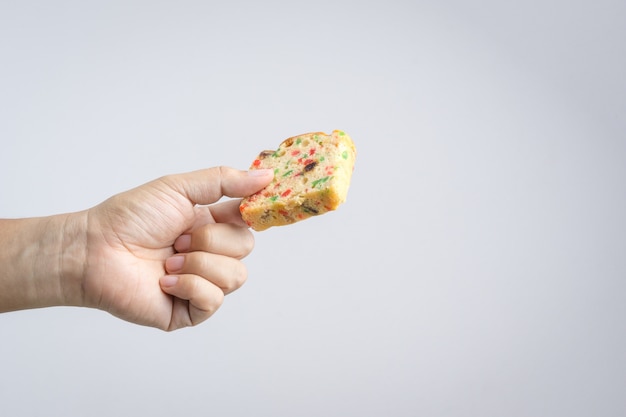 Hand holding traditional fruit cake with raisin, cinnamon and dried cranberries