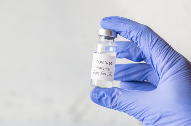 Hand holding the tube of Coronavirus vaccine