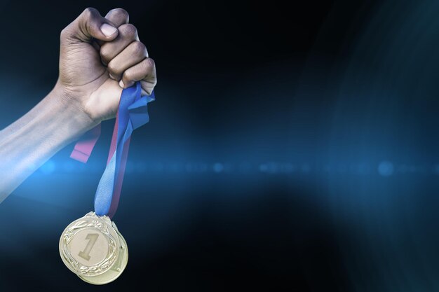 Hand holding two gold medals on white background against spotlights