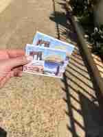 Photo a hand holding two tickets to tipaza region attraction