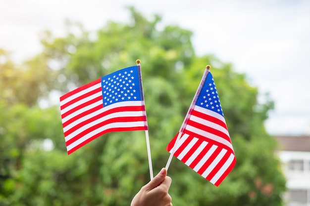 Photo hand holding united states of america flag on green background usa holiday of veterans memorial independence fourth of july and labor day concept