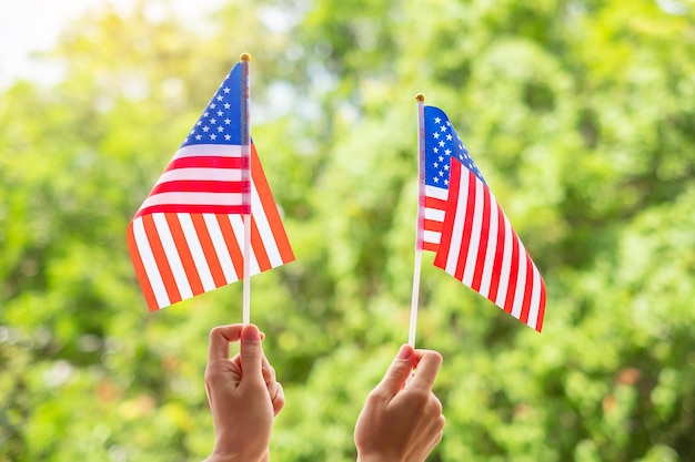 Hand holding united states of america flag on green background
usa holiday of veterans memorial independence fourth of july and
labor day concept