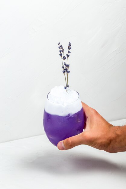 Hand holding unusual purple lavender foam cocktail