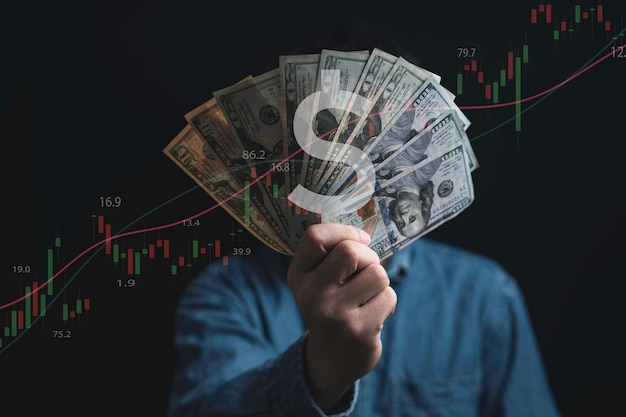 Hand holding USD dollar banknote with stock market chart and increasing arrow for dollar exchange money exchange and inflation interest rating increasing concept