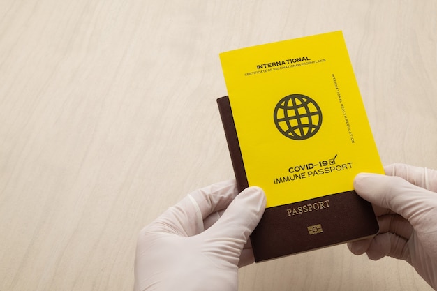 Hand holding vaccine passports as proof that the holder has been vaccinated against Covid-19, Requirement for international travel.