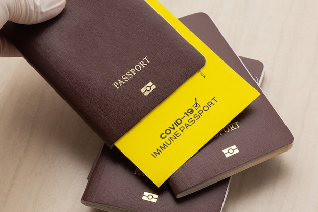 Hand holding vaccine passports as proof that the holder has been vaccinated against Covid-19