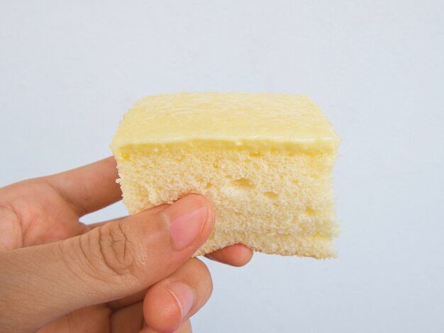 Hand holding vanilla cake, Thailand dessert, White background.