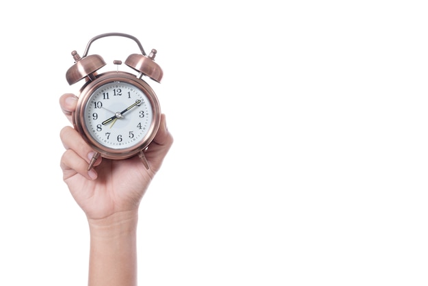 Hand holding vintage alarm clock setting at 7am and showing time over eight o'clock 