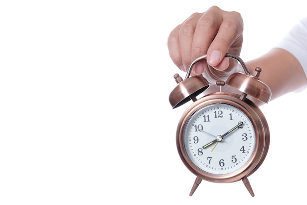 Hand holding vintage alarm clock setting at 7am and showing time over eight o'clock 