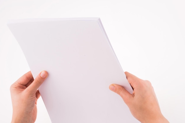 Hand holding a white blank sheet of paper
