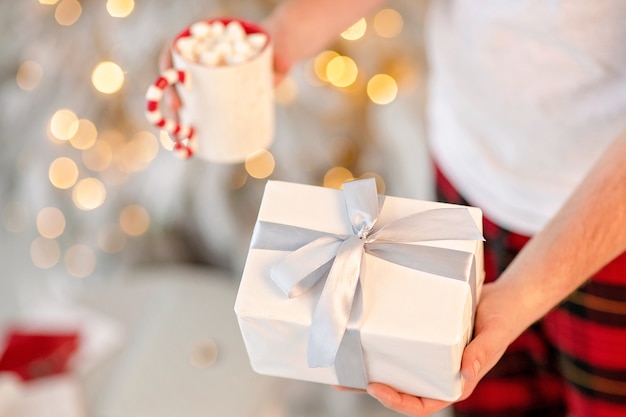 hand holding a white box with gift