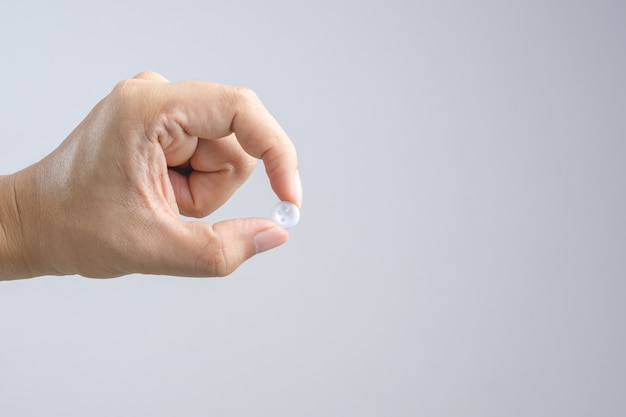 Hand holding white clothing button