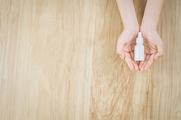 Hand holding a white medicine bottle