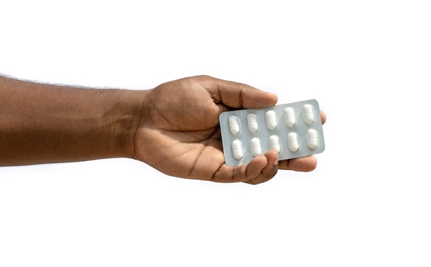 Hand holding a white medicine pack on isolated white background