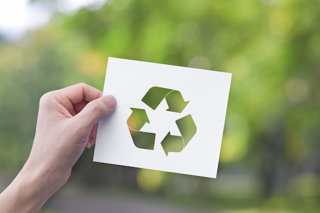 Photo hand holding white paper with recycle symbol