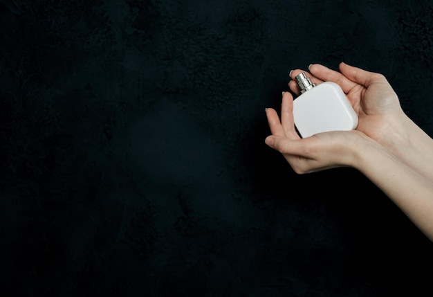 Hand holding white perfume bottle