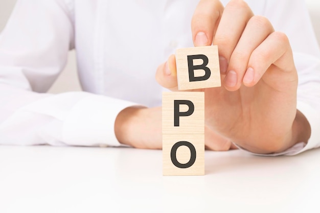 写真 bpo テキスト財務管理経済ビジネスと時間の概念を持つ木製キューブ ブロックを持っている手