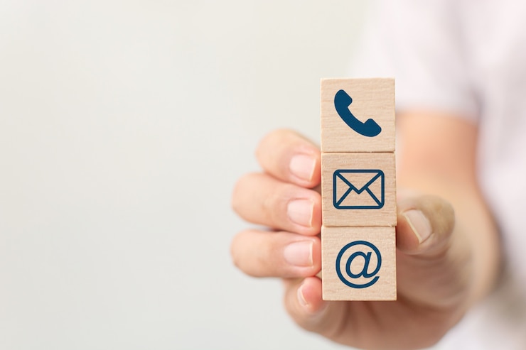 Photo hand holding wooden block cube symbol telephone, email, address. website page contact us or e-mail marketing concept