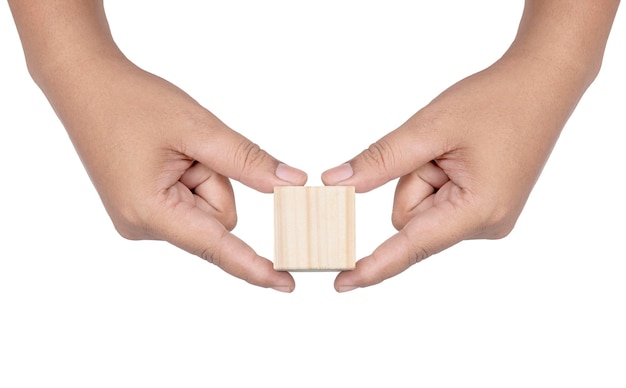 Рука держит деревянную игрушку блока, изолированную на белом фоне