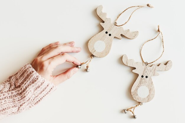 Photo hand holding wooden christmas ornaments eco friendly handmade deer shaped christmas decor