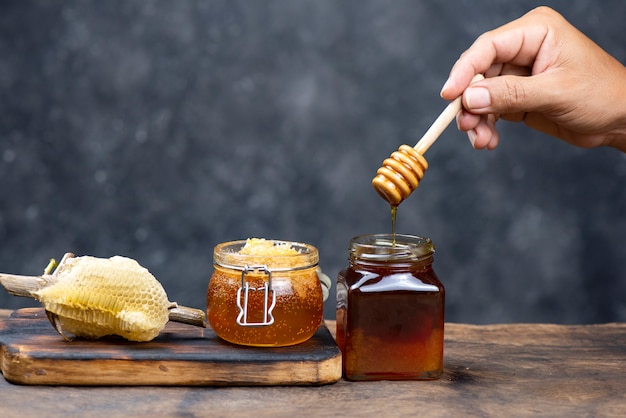 Hand holding wooden honey dipper