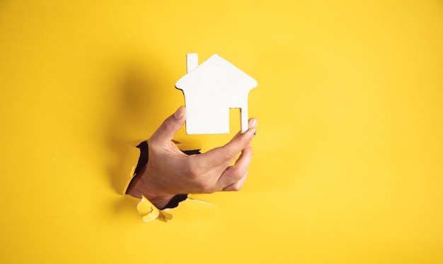 Hand holding a wooden house