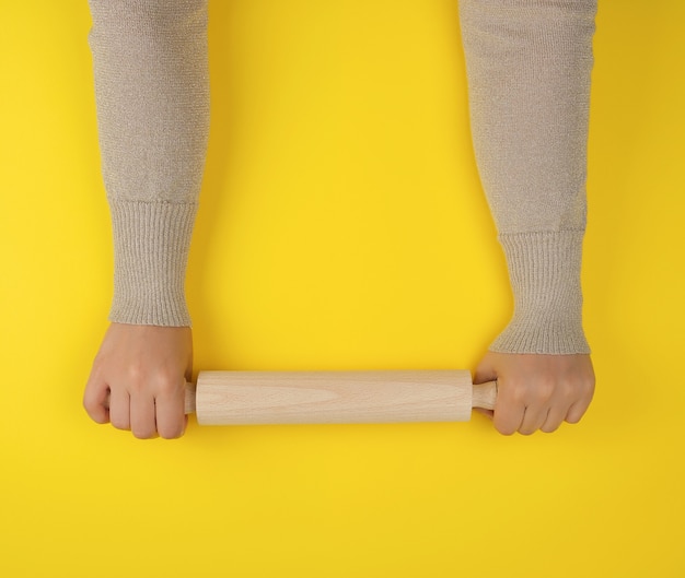 Hand holding a wooden rolling pin