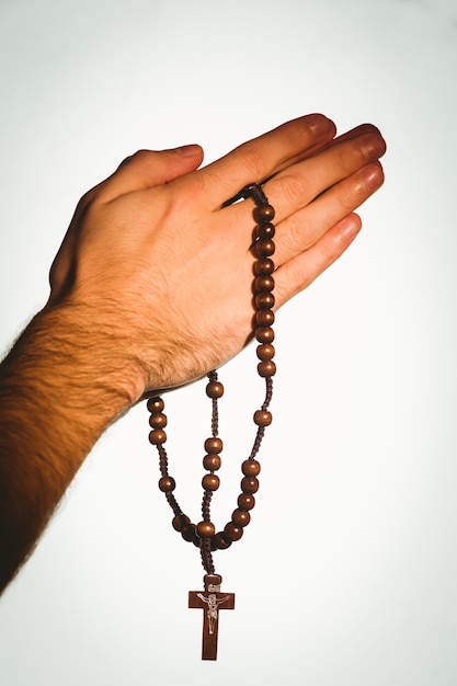 Hand holding wooden rosary beads