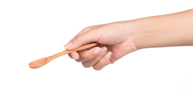 Photo hand holding wooden spoon isolated on white background