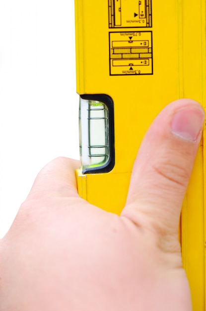 Hand holding yellow level tool