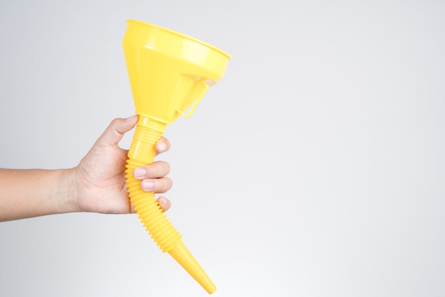 hand holding yellow plastic funnel cone for water or fluid transfer