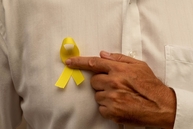 Hand holding a yellow ribbon Yellow may