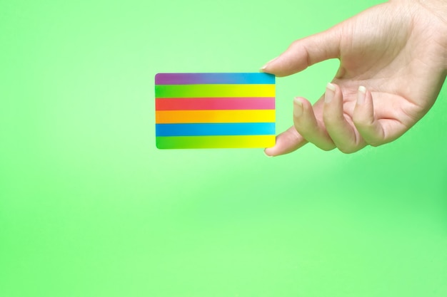 Hand holds a Bank card,on green background.