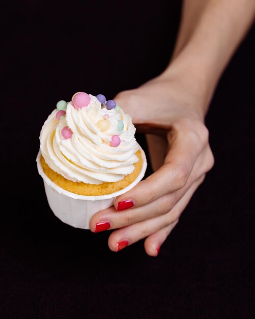 Photo hand holds a bright cake